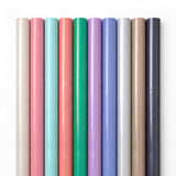 Set of colorful straws arranged in a row on a white background