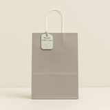 🛍️ Premium Paper Gift Bags – 4-Pack Assorted Colors (12*14*6CM) in gray with twisted handle and floral tag.