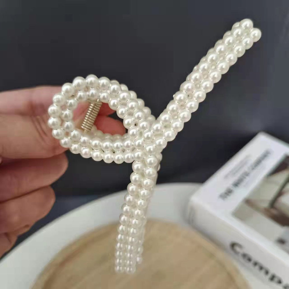 Pearl Bow Hair Clip – Elegant Ribbon Style showcasing a glossy pearl finish and stylish bow design, perfect for hairstyles.
