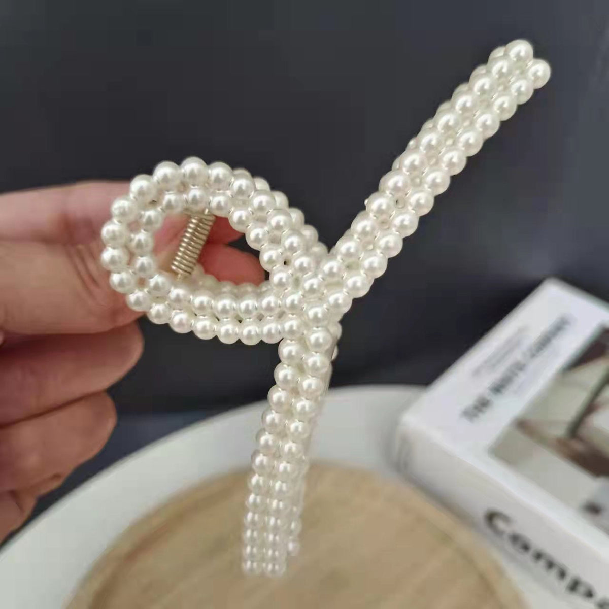 Pearl Bow Hair Clip – Elegant Ribbon Style showcasing a glossy pearl finish and stylish bow design, perfect for hairstyles.