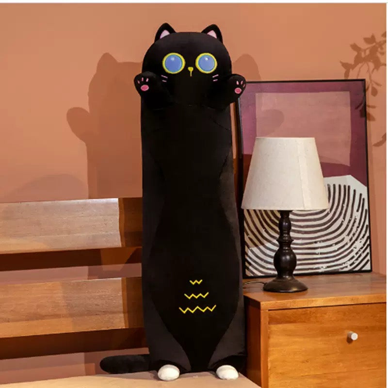 Plush Black Cat 70CM standing next to a table lamp in a cozy room setting.