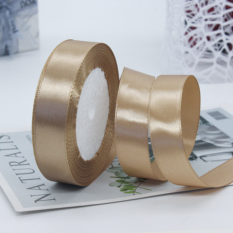 🧵 Premium Satin Ribbon – Versatile & Elegant, luxurious gold ribbon on a spool, ideal for gift wrapping and crafts.