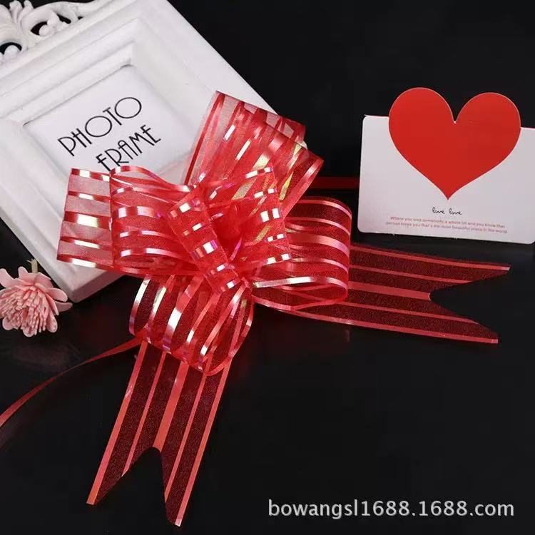 Pulling Ribbon(10PCS/3*47CM) in red decorative bow style displayed with a photo frame and heart card.